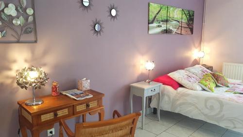 une chambre avec un lit, une table et un bureau dans l'établissement Domaine de la Dame Blanche, à Siorac-en-Périgord