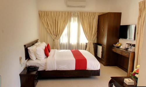 a hotel room with a bed and a window at Calangute Grande in Calangute