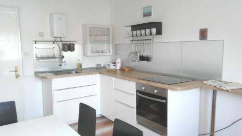 a kitchen with white cabinets and a counter top at Vila Rosa in Vis