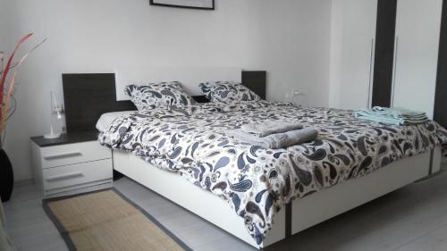 - une chambre avec un lit et une couette noire et blanche dans l'établissement Vila Rosa, à Vis
