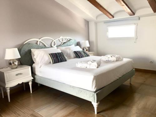 um quarto com uma cama grande com lençóis brancos e almofadas em Casa Boquera em Carche