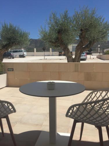 a white table and two chairs and a table and two trees at Casa Boquera in Carche