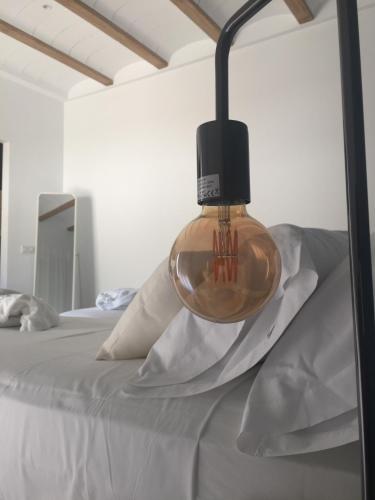 a light on top of a bed with pillows at Casa Boquera in Carche