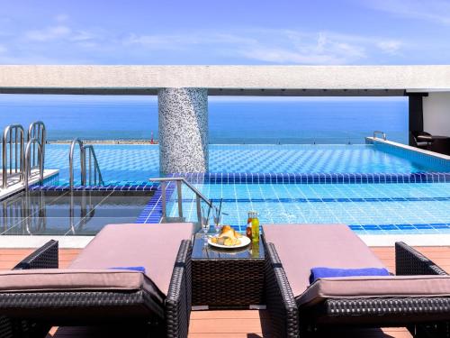 a view of a swimming pool from the deck of a resort at Grabel Hotel Jeju in Jeju