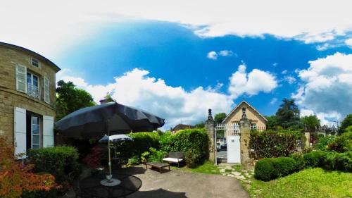 une terrasse avec un parasol et une maison dans l'établissement La Maison du Notaire Royal, à Sarlat-la-Canéda