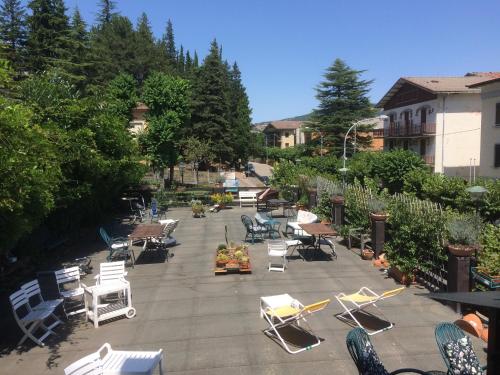 a group of lawn chairs and lounge chairs on a patio at Villa Fedora in Lizzano in Belvedere