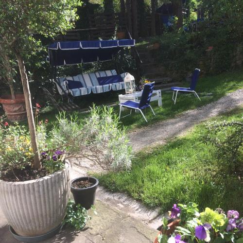 two blue chairs and a bench in a garden at Villa Fedora in Lizzano in Belvedere
