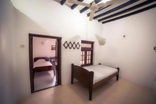 una camera da letto con specchio e letto di Karibu Inn a Zanzibar City