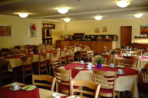 un comedor con mesas y sillas con mantel rojo en St. Jobser Hof en Würselen