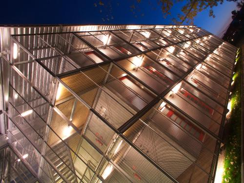 a building with a glass facade at night at Orange Wings Krems in Krems an der Donau