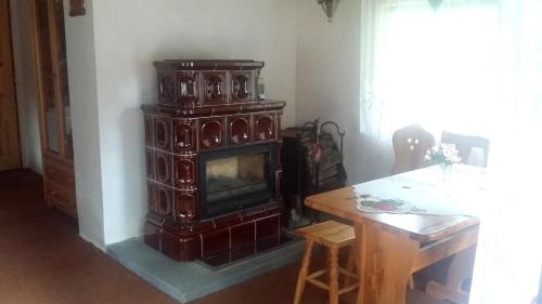a woodburning stove in a living room with a table at Chata Dolce I in Trutnov