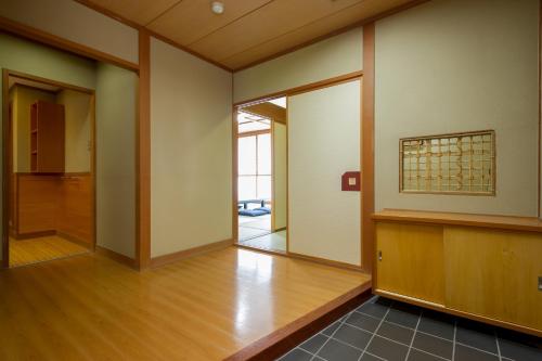 an empty room with wood floors and a glass door at kinugawaonsen Fukumatsu in Nikko