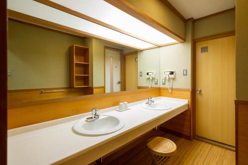 a bathroom with two sinks and a large mirror at kinugawaonsen Fukumatsu in Nikko