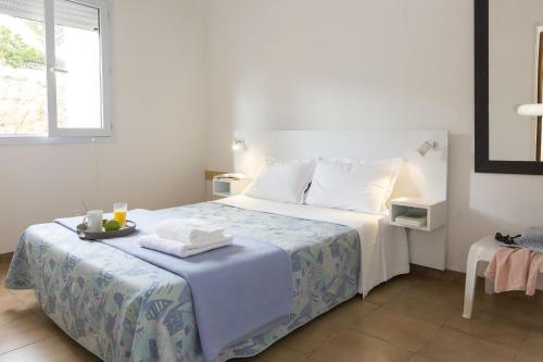 Dormitorio blanco con cama y bandeja en Résidence Odalys Stella di l'Aria en Tizzano