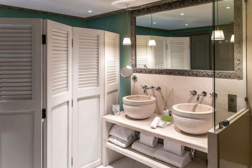 uma casa de banho com uma banheira, um lavatório e um espelho. em Hôtel Villa Marie Saint Tropez em Saint-Tropez