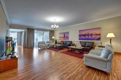 a living room with couches and a flat screen tv at J5 Villas Holiday Homes Barsha Gardens in Dubai