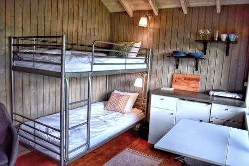 a room with two bunk beds and a desk at Solbakken Cabins in Geiranger
