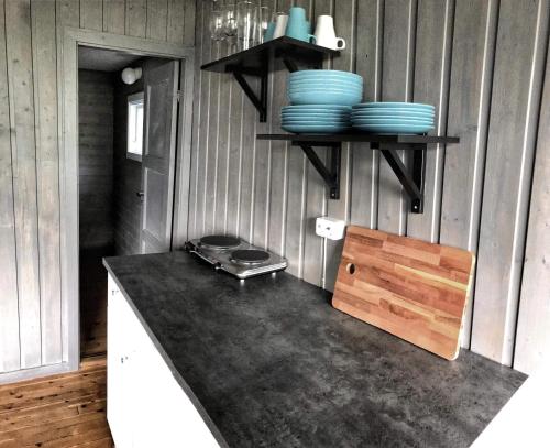 a kitchen with a counter with blue plates on the wall at Solbakken Cabins in Geiranger