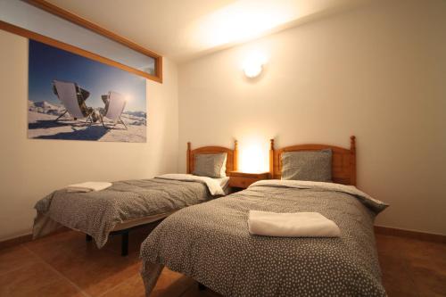 a bedroom with two beds and a painting on the wall at Pont de Toneta 3,5 Ransol, Zona Grandvalira in Ransol