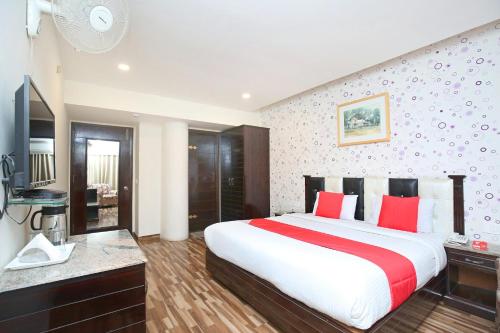 a bedroom with a large bed with red pillows at Akashdeep 22 in Chandīgarh