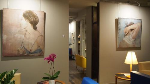 a hallway with a painting of a woman on the wall at Hotel Lucerna in Castiglione della Pescaia