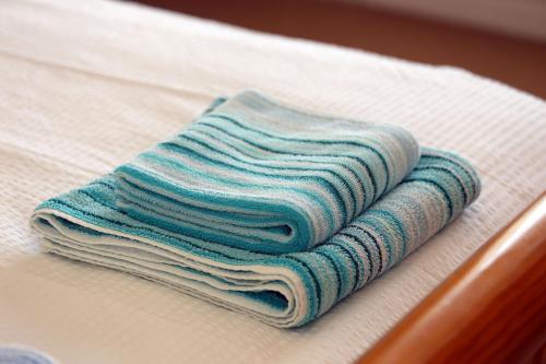 - une pile de serviettes assises au-dessus d'un lit dans l'établissement Lazy Days Cottage, à Winterton-on-Sea