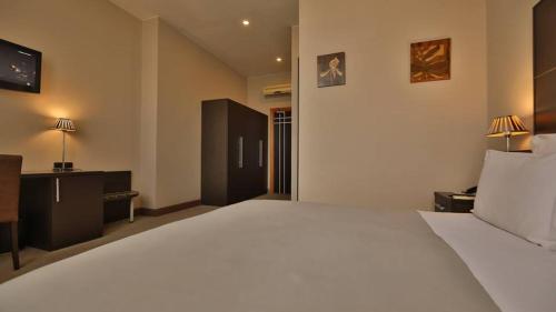 a bedroom with a large white bed in a room at TANA-Boutique Hôtel in Antananarivo
