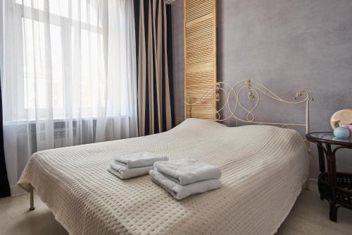 a bedroom with a bed with towels on it at Studiominsk 9 Apartments in Minsk