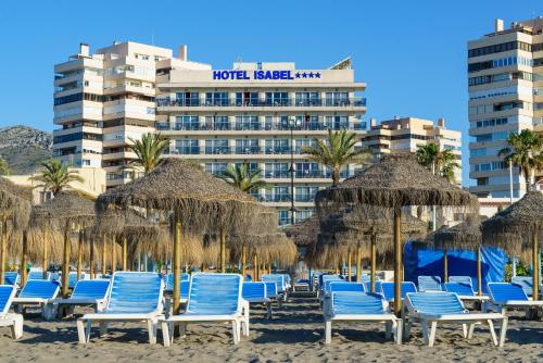 a group of chairs and umbrellas on a beach at Hotel Isabel in Torremolinos