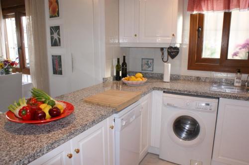 uma cozinha com uma tigela de frutas e uma máquina de lavar louça em Calle Rigoletto Villamartin Costa Blanca em Villamartin