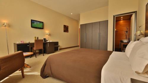 a hotel room with a large bed and a desk at TANA-Boutique Hôtel in Antananarivo