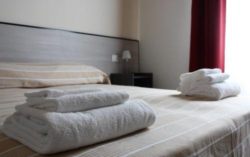 two stacks of towels sitting on top of a bed at La Formica in Civitavecchia