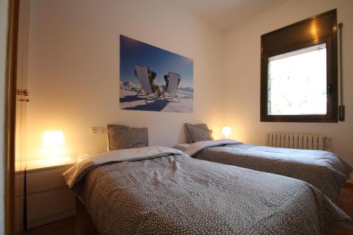 two beds in a room with a window and two lamps at Pont de Toneta 4,1 Ransol, Zona Grandvalira in Ransol