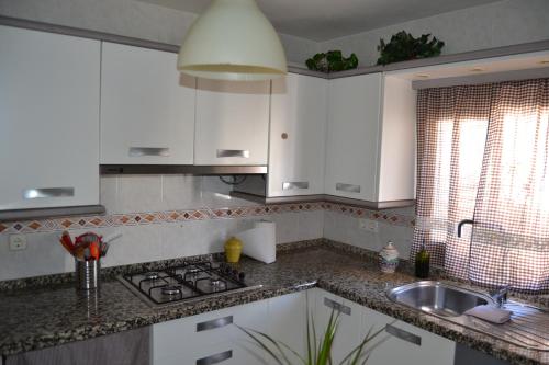 アラセナにあるCasa Torrubiaの白いキャビネットとシンク付きのキッチン
