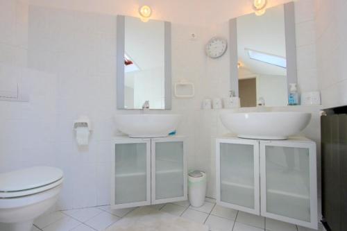 a white bathroom with two sinks and a toilet at 3 Bedroom Private floor in Luxury Mansion in Budapest