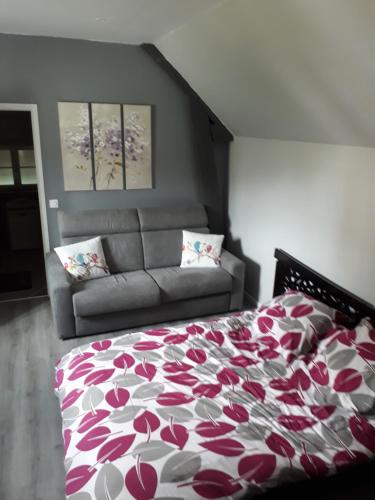a bedroom with a bed and a couch at la ville à la campagne in Lisieux