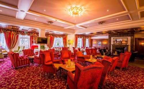 リエンツにあるGrandhotel Lienz Business-Wellness & Gourmetの赤い椅子と暖炉付きの広い部屋