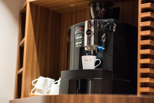 a coffee machine sitting on a counter with cups at the b akasaka in Tokyo