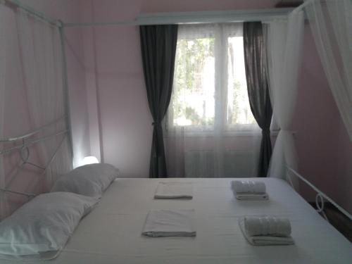 a bedroom with a bed with two towels on it at "ΙωΚαρ" in Nafpaktos