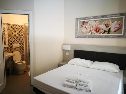 Un dormitorio con una cama con dos toallas encima. en IL Sole, en Roma
