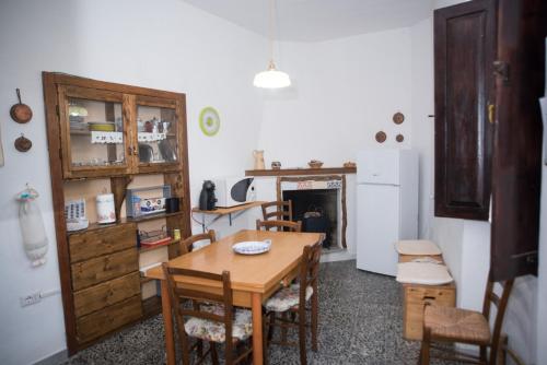 cocina con mesa, sillas y nevera en Green House en Villaputzu