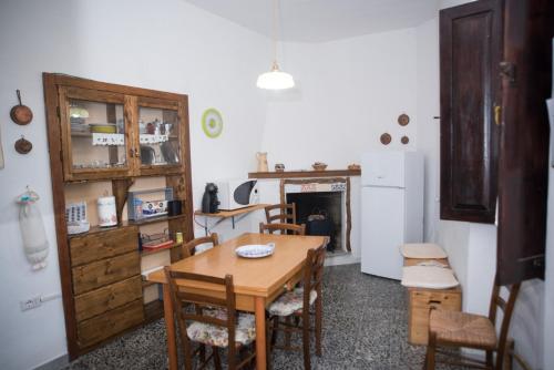 una cucina con tavolo, sedie e frigorifero di Green House a Villaputzu