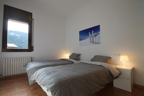 two beds in a white room with a window at Pont de Toneta 4,4 Ransol, Zona Grandvalira in Ransol