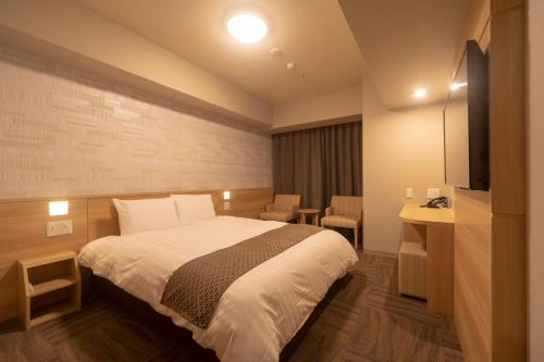 a hotel room with a bed and a television at Dormy Inn Premium Namba ANNEX Natural Hot Spring in Osaka