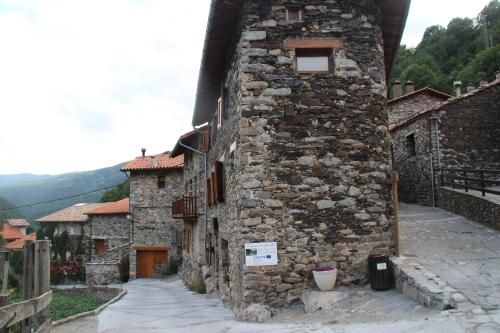an old stone building with a door on a street at Apartaments Can Bundanci in Setcases