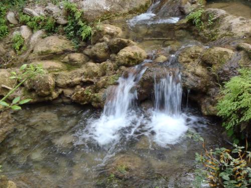 a small waterfall in a creek with rocks at Hotel & Spa PLAZA Arriate in Arriate