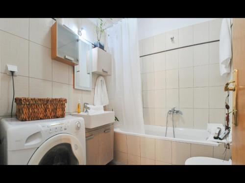 a bathroom with a washing machine and a sink at Athanasia's Apartments in Prinos