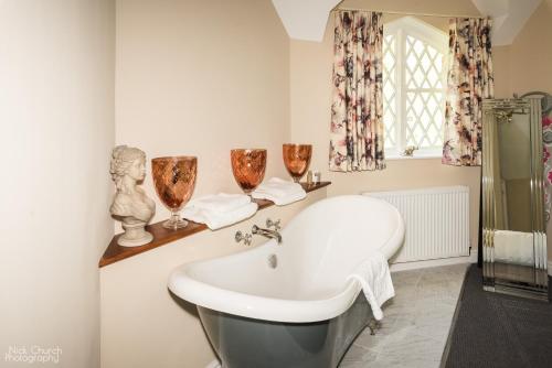 y baño con bañera y lavamanos. en The Coach House Apartment at Cefn Tilla Court, Usk en Usk