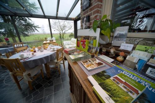 um restaurante com uma mesa e cadeiras e uma janela em B&B Artiriacumhoeve em Zedelgem