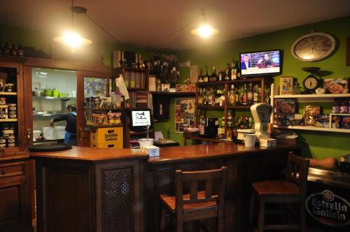 a bar in a pub with a man standing at the counter at Casa Les Pedroses in Campiellos